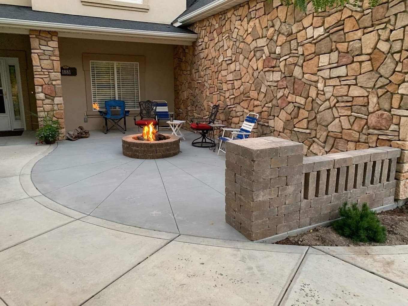 Concrete patio with stone fireplace and seat wall