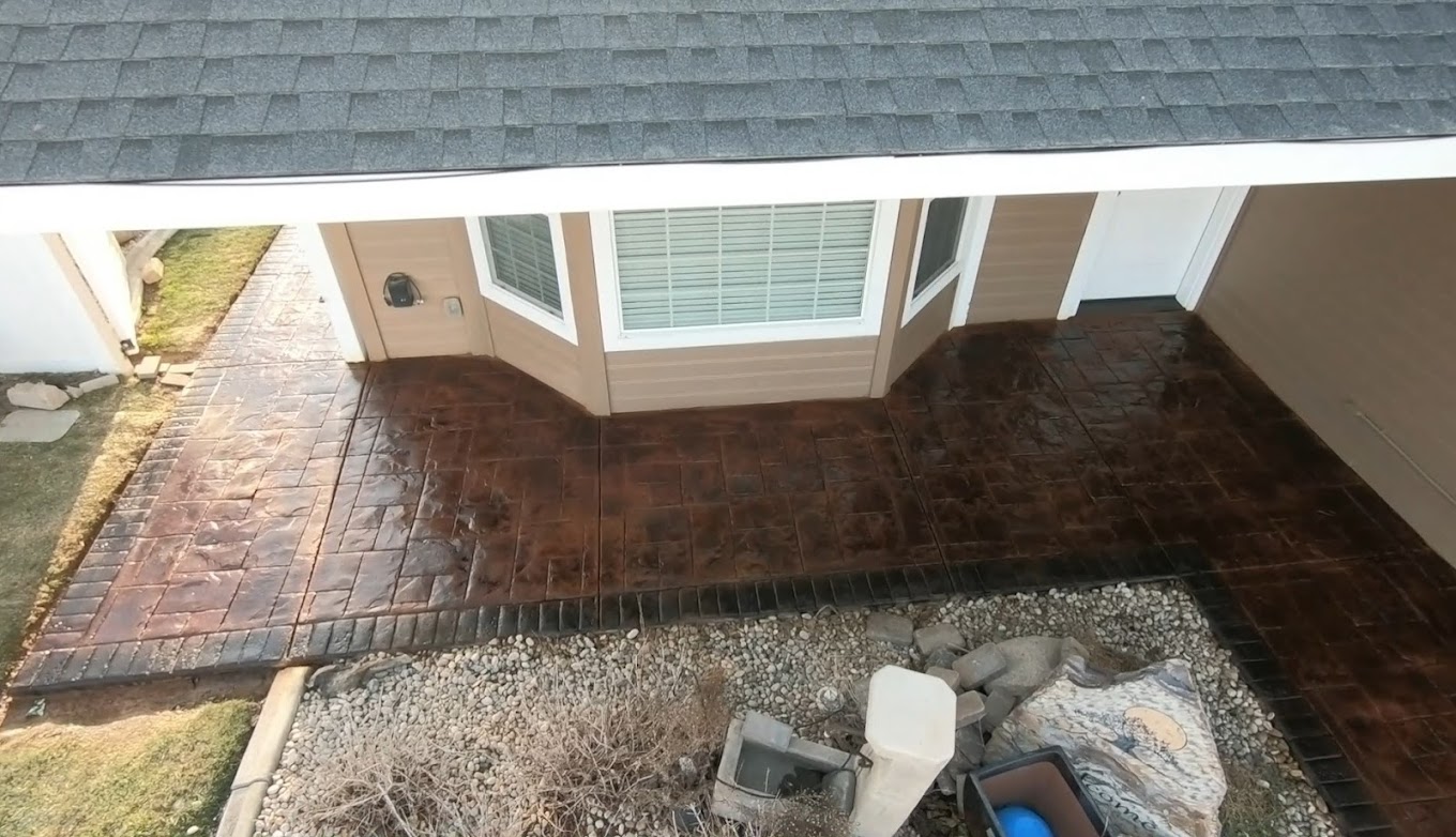 Rich brown stamped concrete walkway along home exterior
