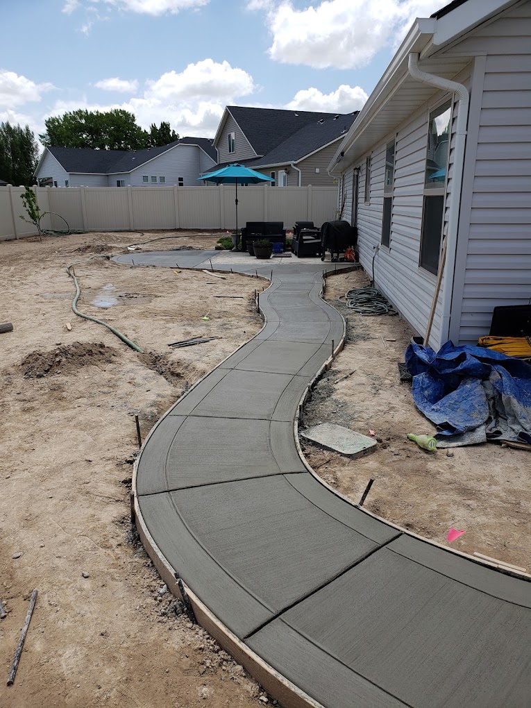 Curved poured concrete sidewalk connecting home to patio